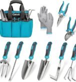 A variety of ergonomic gardening hand tools arranged on a wooden potting bench.