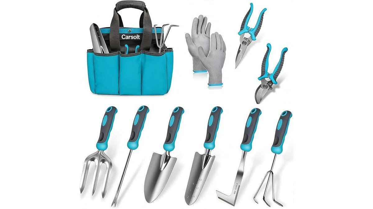 A variety of ergonomic gardening hand tools arranged on a wooden potting bench.