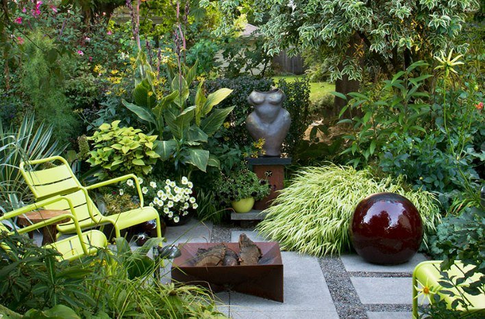 Compact courtyard garden with vertical planters and wooden bench in soft natural light