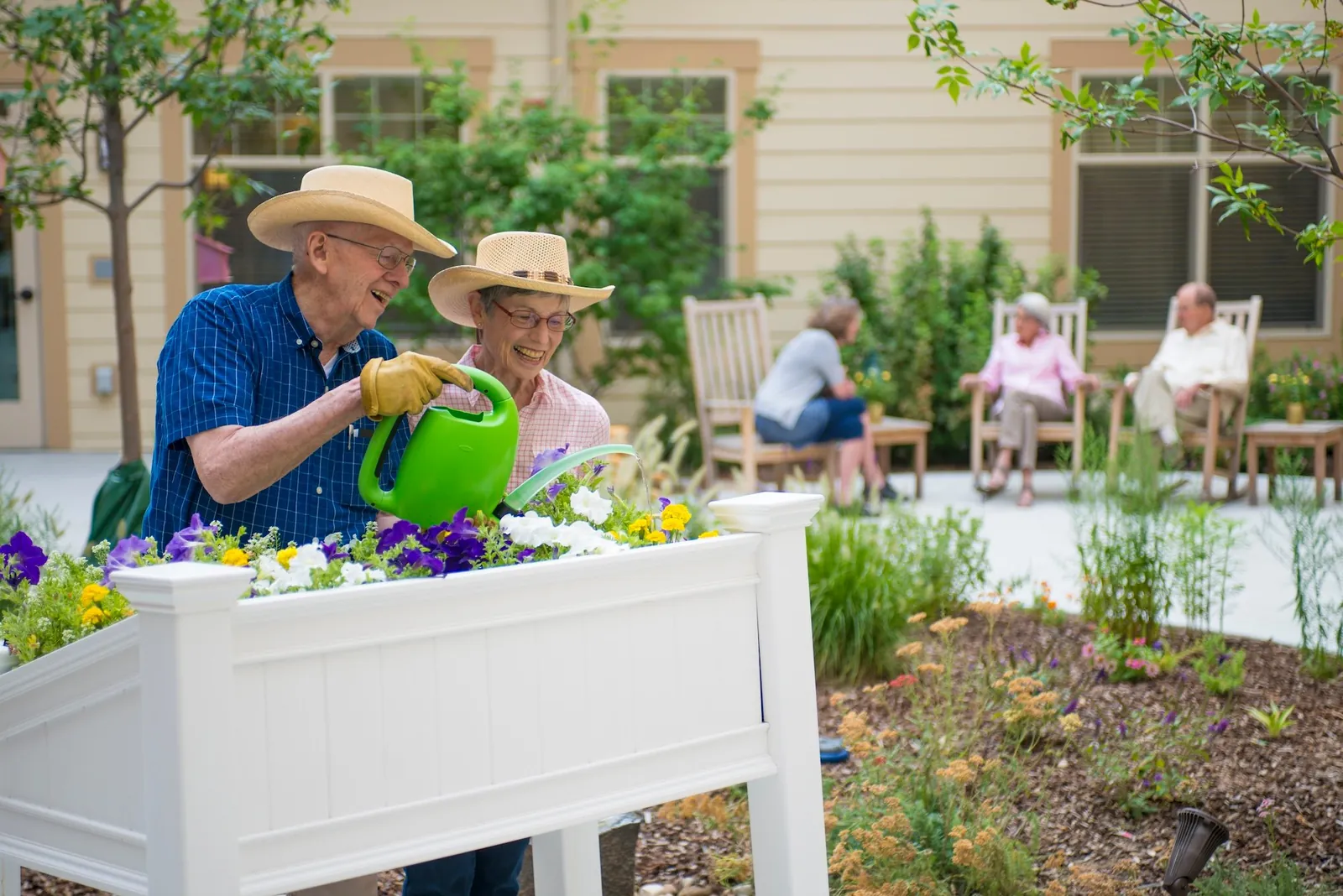 Lightweight, ergonomic gardening tools on a wooden table near a raised bed